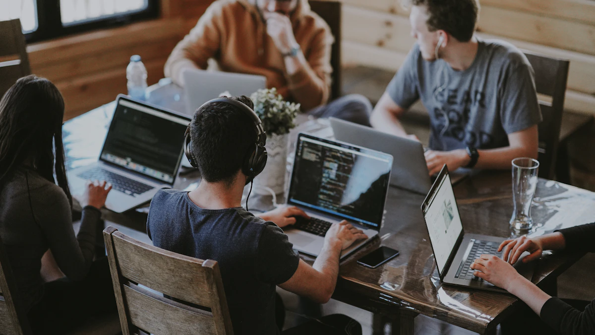 Engineers working together on laptops around a shared table